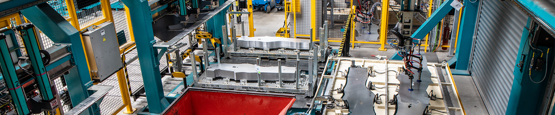 Blick in eine Produktionsstätte, in der auf einer Maschinenstraße Autoteile aus Metall gefertigt werden.