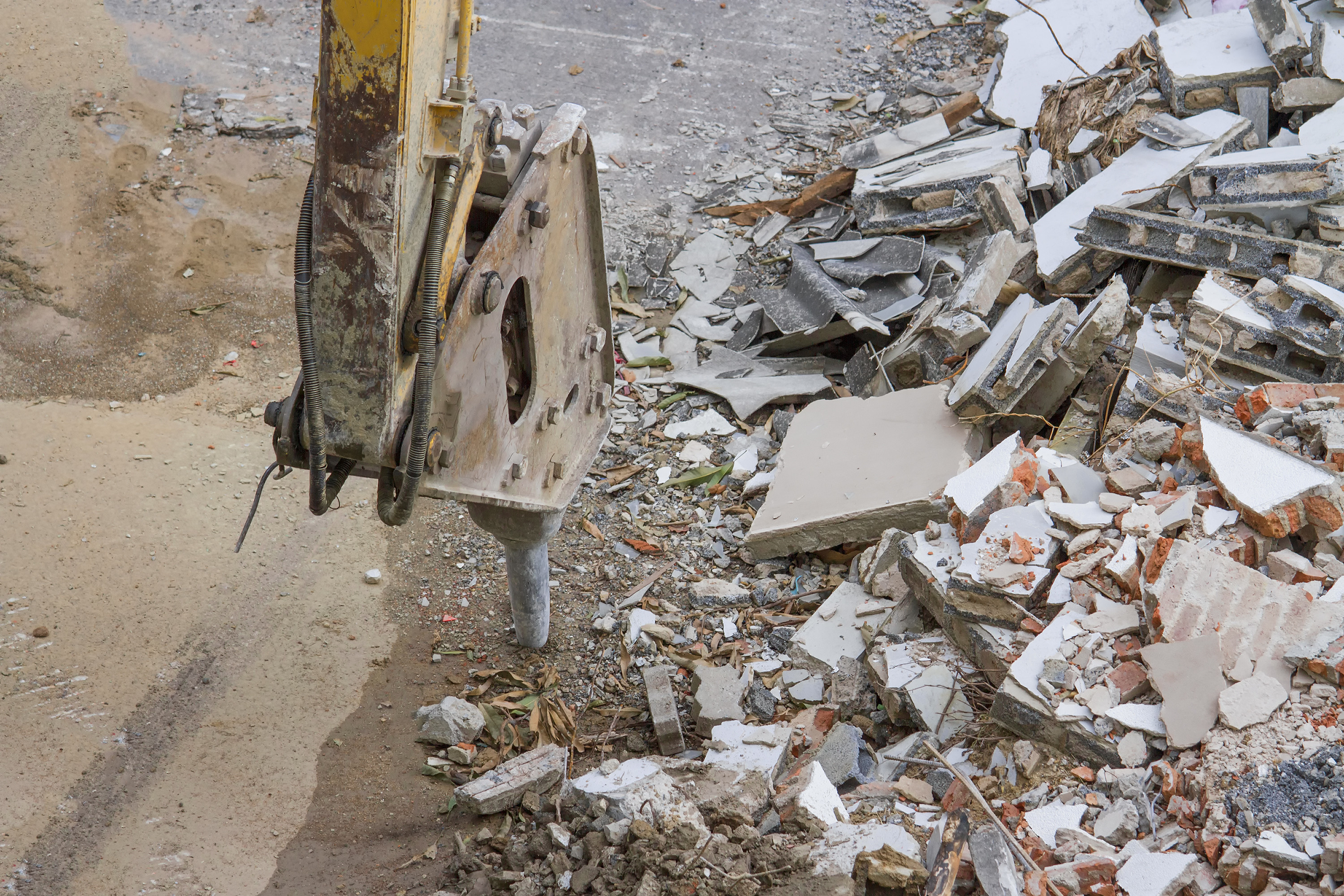 Das Bild zeigt den Abbruch eines Industriegebäudes mit einer Betonbohrmaschine. Neben der Maschine liegt Bauschutt.